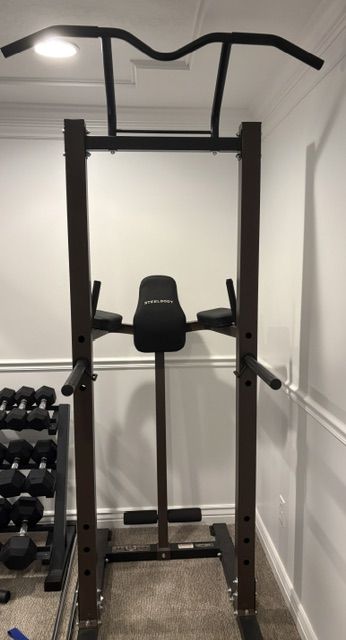 Pull-up bar, dip station, vertical knee raise pads, and sit-up foot rollers.  SteelBody Power Tower STB-98501