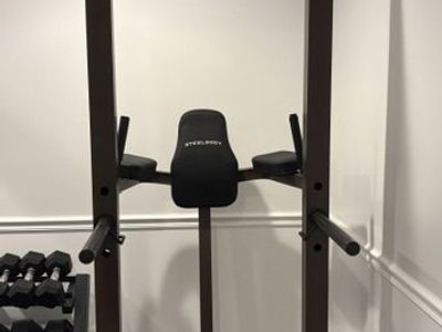 Pull-up bar, dip station, vertical knee raise pads, and sit-up foot rollers. SteelBody Power Tower STB-98501