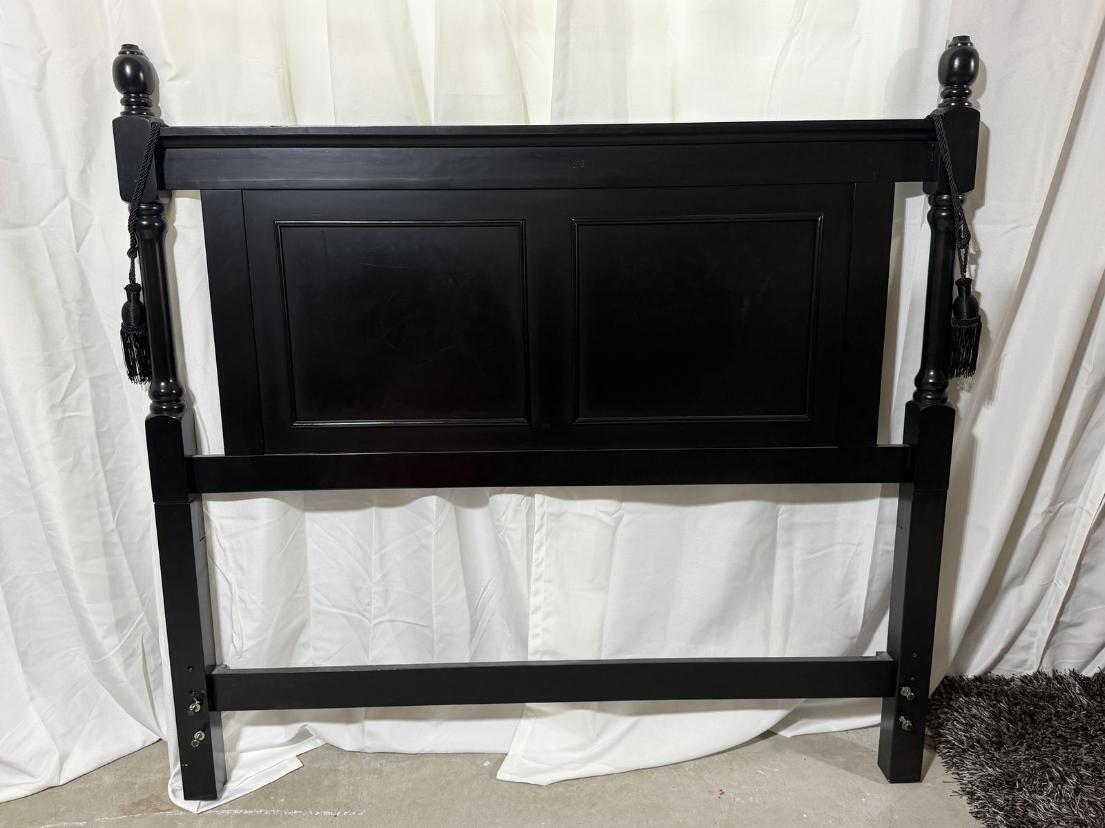 Black Wooden Headboard with Decorative Finials and Tassels