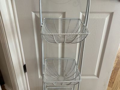 3 Tiered White Metal Basket Stand. Approximately 43” Tall, 10 1/2” Wide.