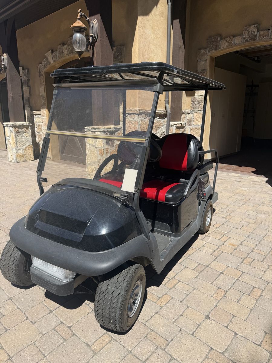 Black Golf Cart with Red and Black Interior Seats and Roof Canopy