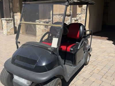 Black Golf Cart with Red and Black Interior Seats and Roof Canopy