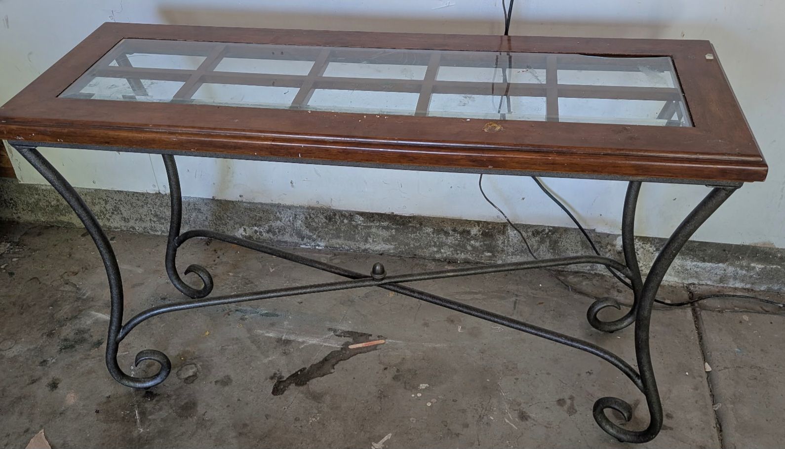 Glass top coffee table with wood frame and metal legs.