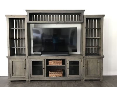 Smoke colored entertainment center 10ft wide, 88” high.