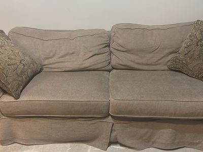 Used Beige Two-Seater Couch with Skirt and Throw Pillows
