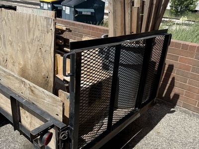 Single axle flat bed trailer with ramp.