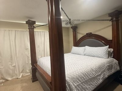 Grand Wooden Four Poster Canopy Bed with Carved Columns and Upholstered Headboard