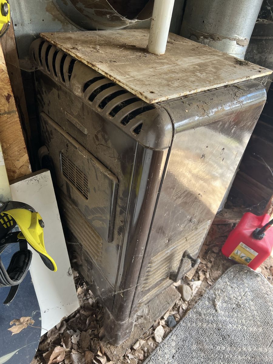 Vintage Wood Burning Stove. Very heavy. Missing one leg. Includes chimney pipes