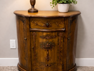 French Provincial cabinet with a beautiful curved (bombé) front and floral detailing.