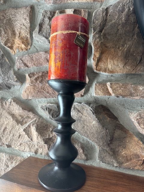 decorative pillar candles on tall black pedestal candle holders