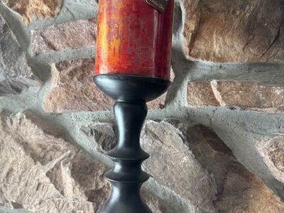 decorative pillar candles on tall black pedestal candle holders