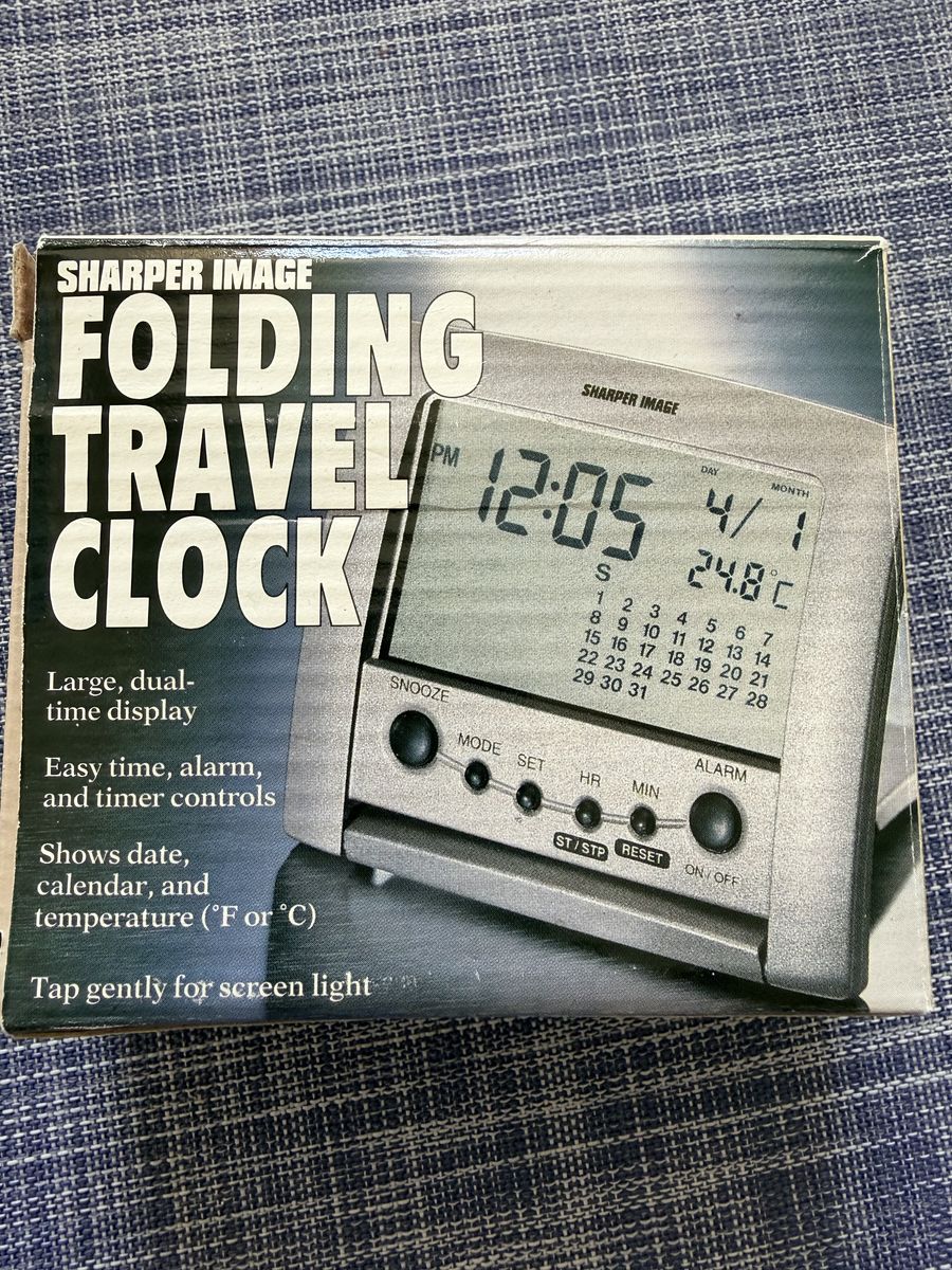 This is a Sharper Image Folding Travel Clock with a digital display and temperature tracker.