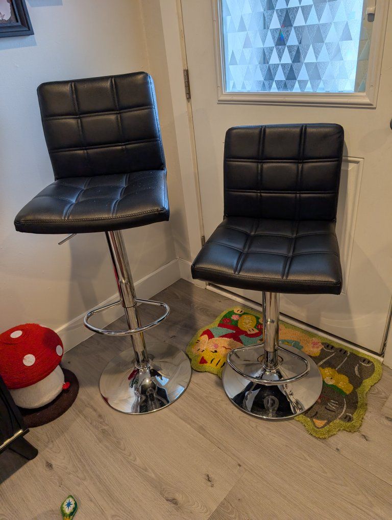 Black adjustable stools, sitting curbside