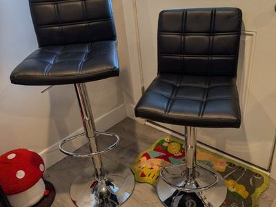 Black adjustable stools, sitting curbside