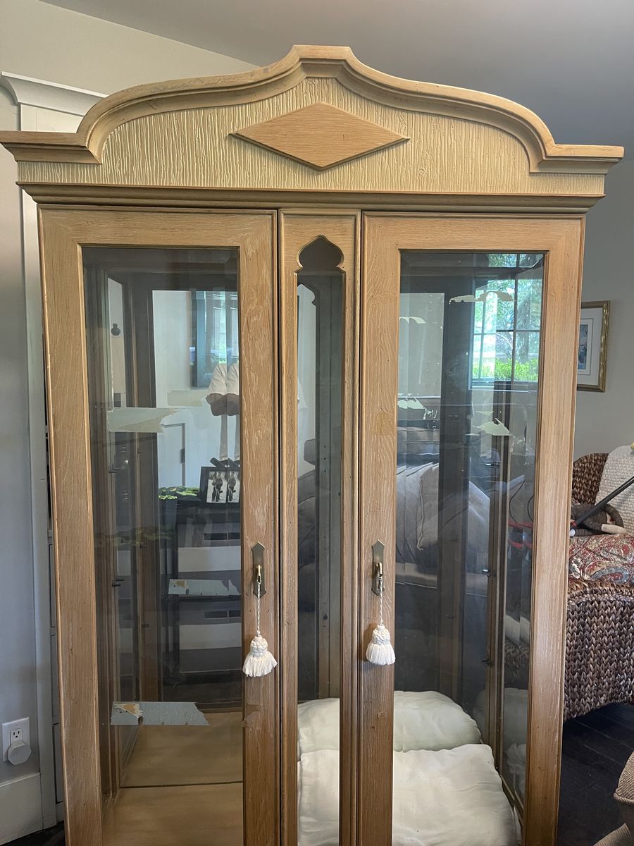 Vintage Light Wood Display Cabinet with Glass Doors and Decorative Top Accent