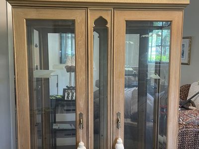 Vintage Light Wood Display Cabinet with Glass Doors and Decorative Top Accent
