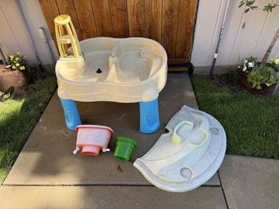 Sand and water table with cover and opening for umbrella