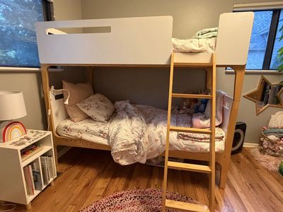 Modern Wooden Twin Bunk Bed with White Panels and Attached Ladder