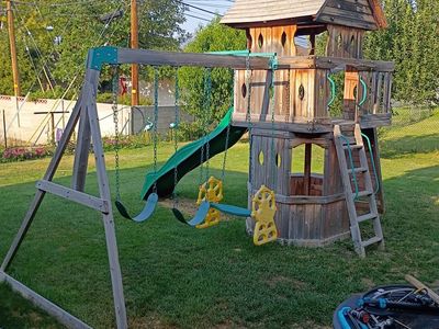 Outdoor Wooden Swing Set with Wave Slide, Two Swings, Two-Person Glider, and Playhouse Fort