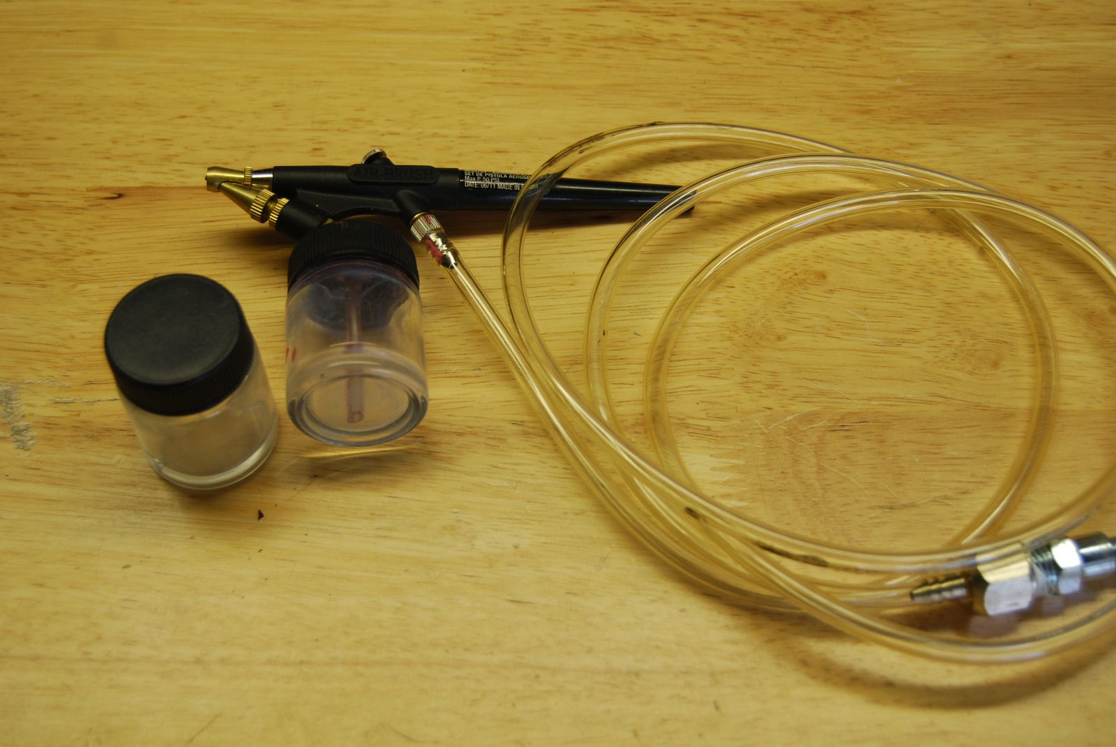 Airbrush with hose, fitting and two bottles.