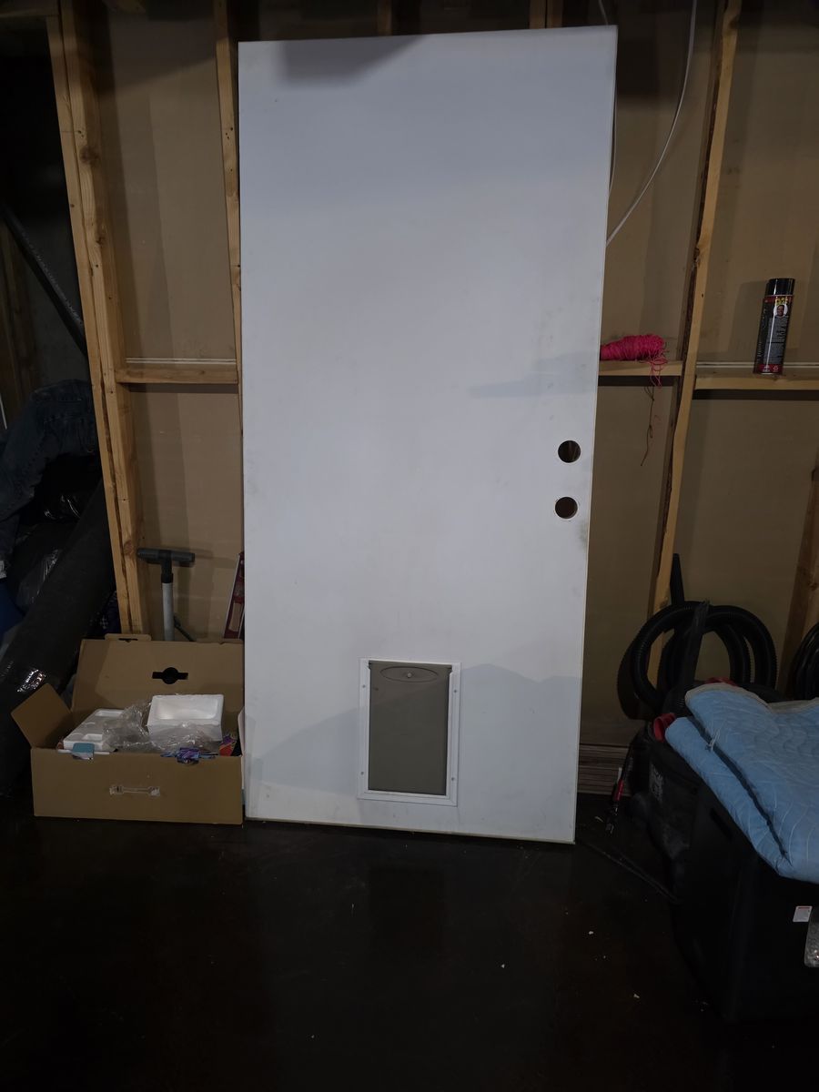 Metal exterior door with doggie door in it