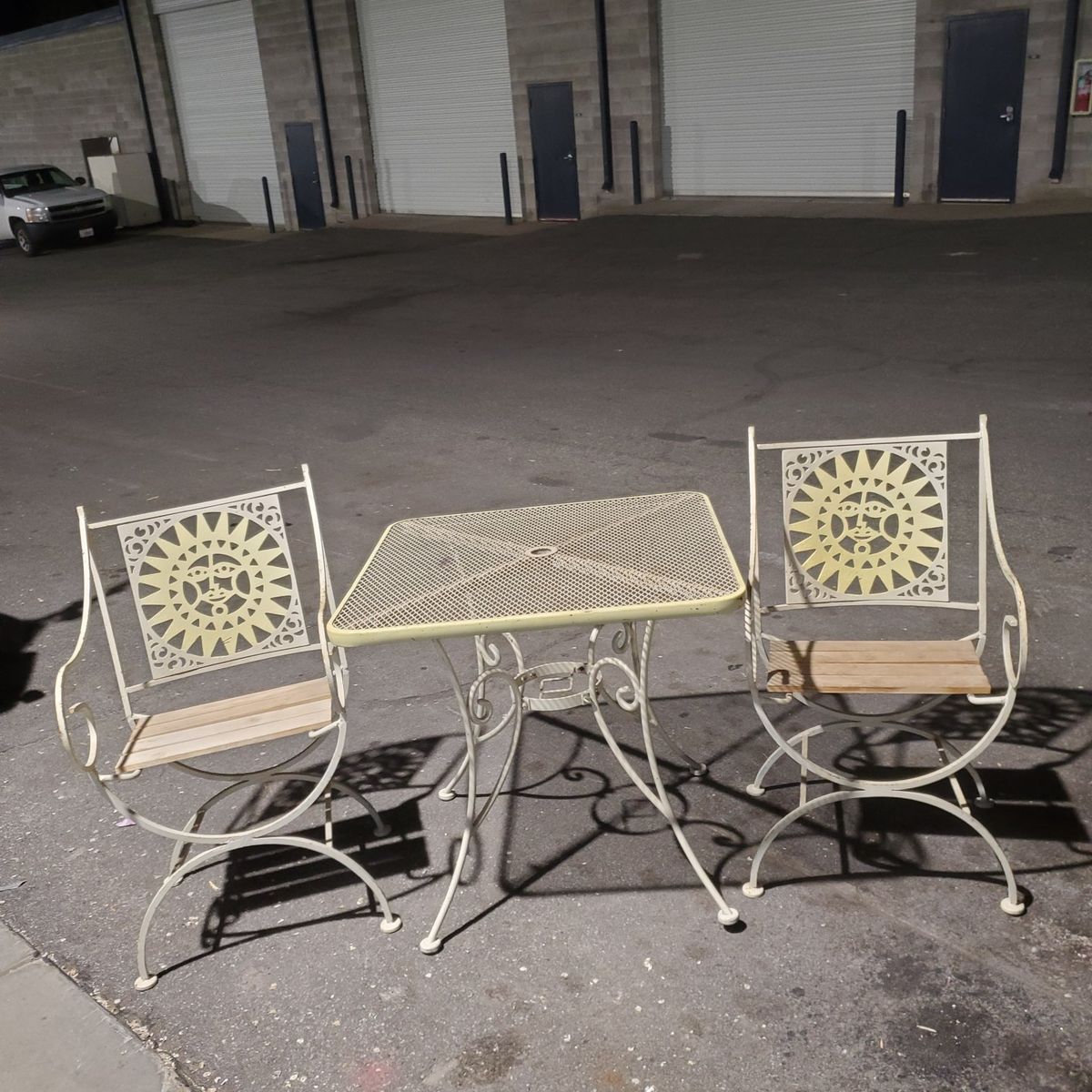 2 rod iron yard chairs and a table