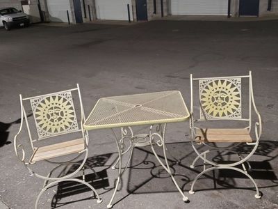 2 rod iron yard chairs and a table