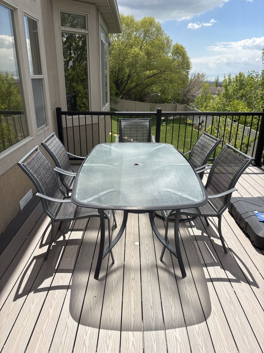 Used glass and metal patio table w/5 chairs