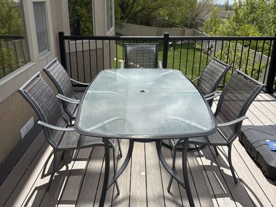 Used glass and metal patio table w/5 chairs
