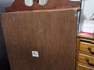 wall-mountable curio cabinet made of cherry-colored wood. It features double glass doors, 3 interior shelves for display