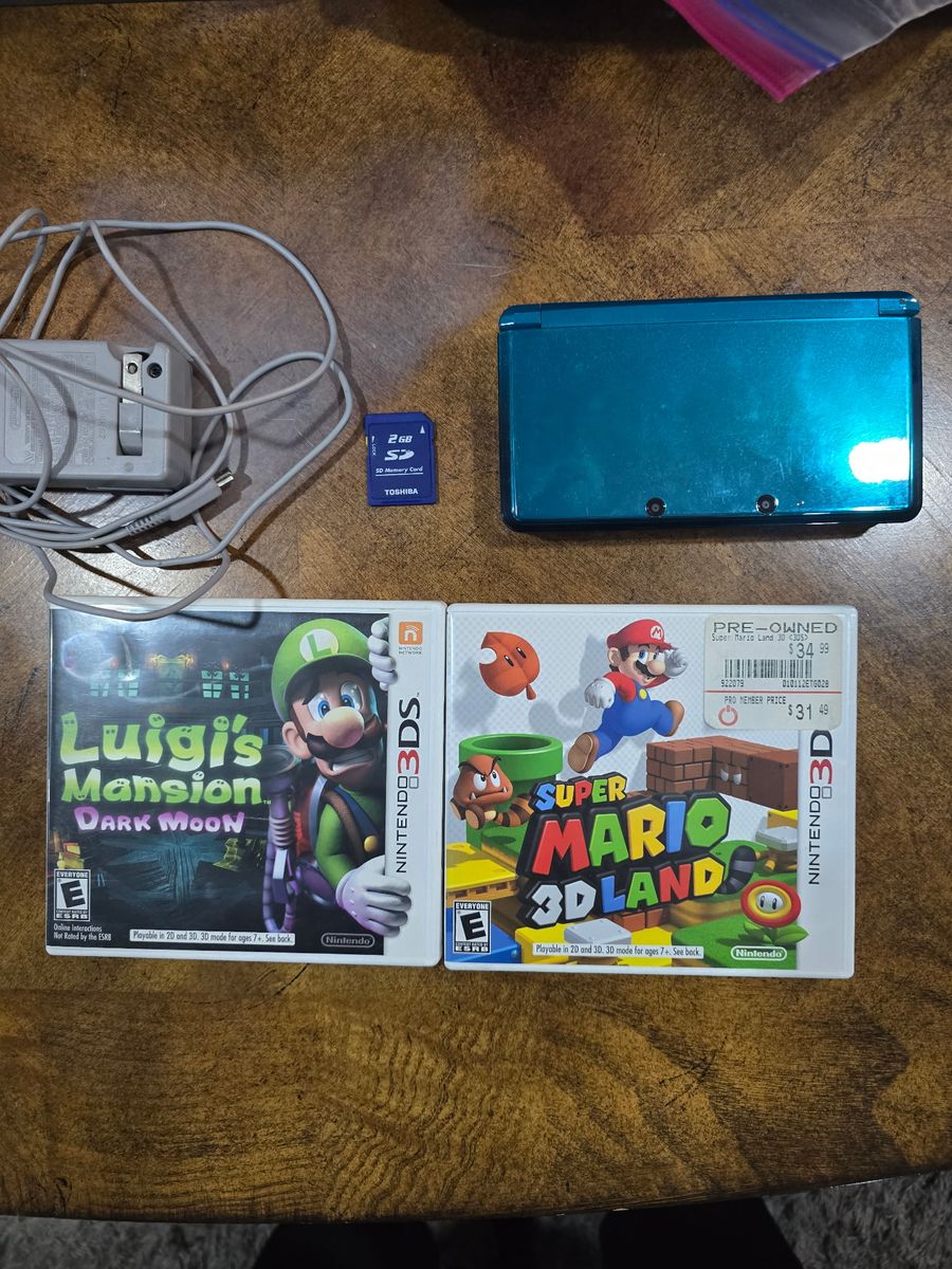 Nintendo 3DS W/ charger and 2 gb sd card. Includes Luigis Mansion Dark Moon and Super Mario 3D Land