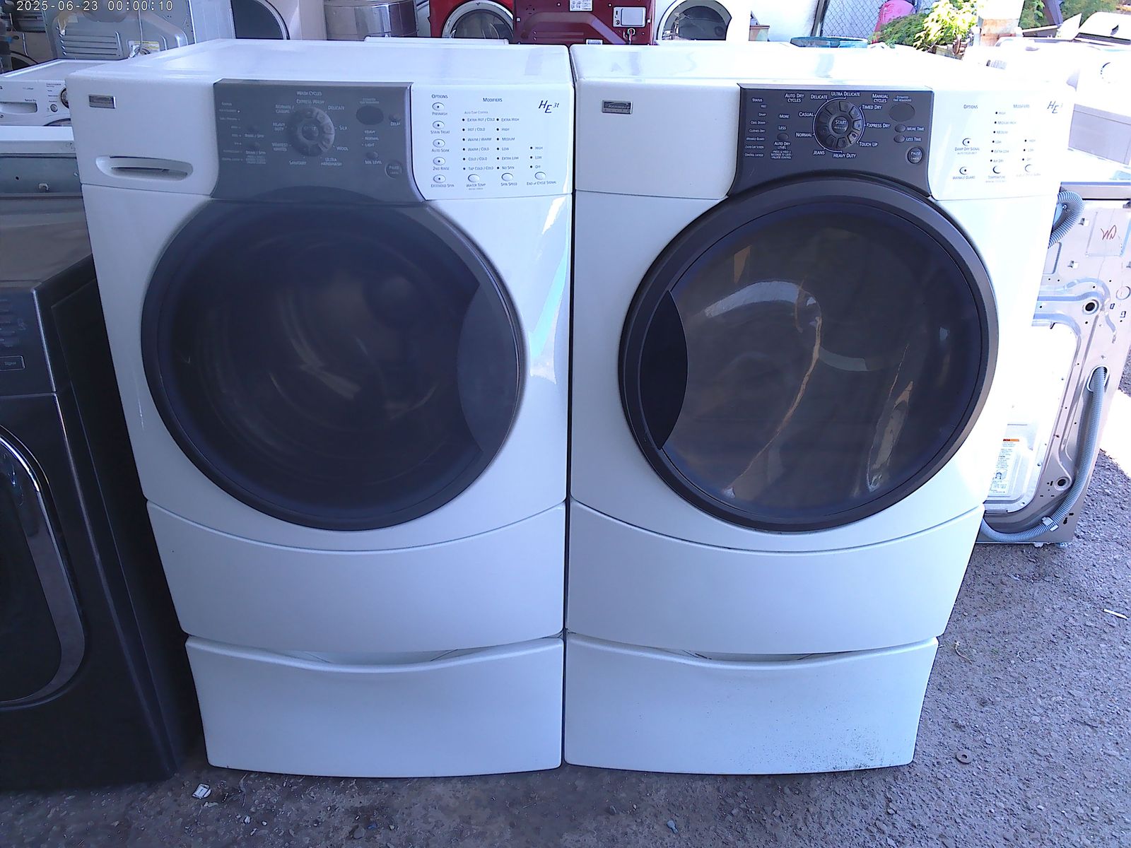 Kenmore Elite front load washer with matched electric dryer on pedestals