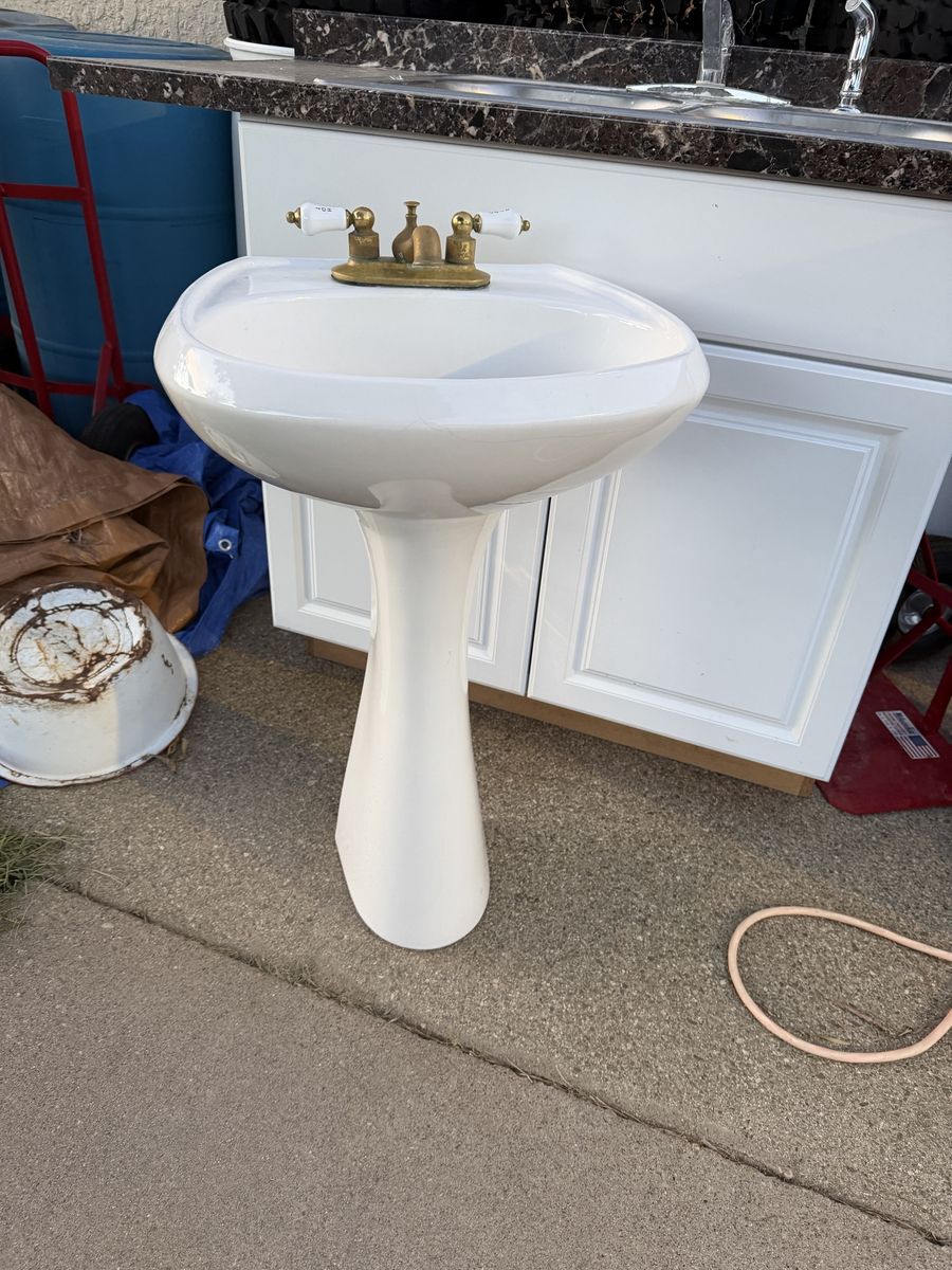 White Pedestal Sink with Brass and White Porcelain Faucet Fixtures Used