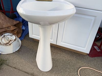 White Pedestal Sink with Brass and White Porcelain Faucet Fixtures Used