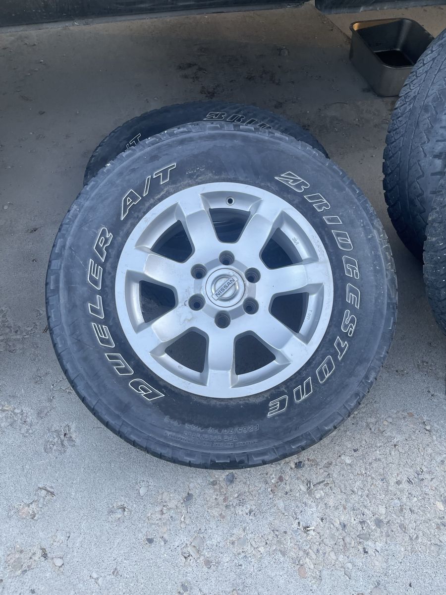 Bridgestone Dueler A/T P285/70R17 Tires & Nissan Titan 17" Wheels - Set of 4
