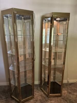 a pair of Howard Miller brass-finished corner curio display cabinets