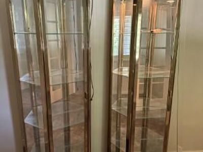 a pair of Howard Miller brass-finished corner curio display cabinets