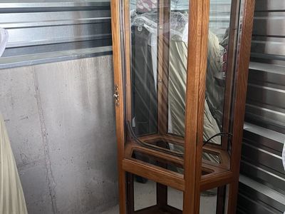 Solid oak curio cabinet with mirror and light inside .