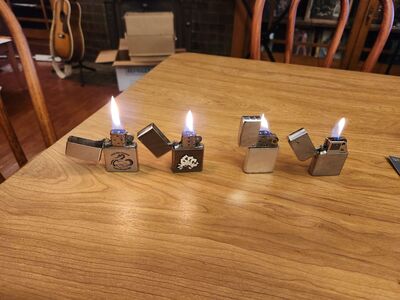 Four working Zippo lighters, 6 flints, one wick, and Ronson lighter fluid.