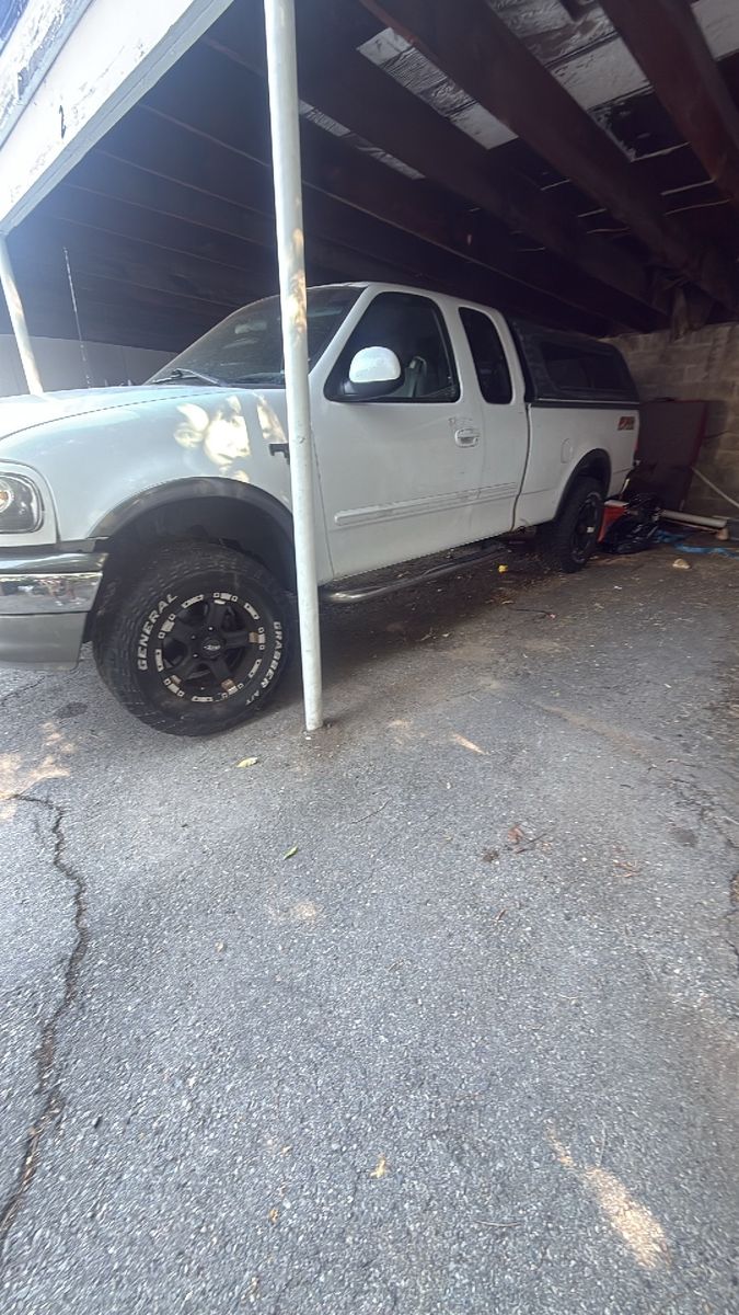 For sale or trade 600$ White Ford F-150 SuperCab Pickup Truck with Camper Shell & Custom Wheels
