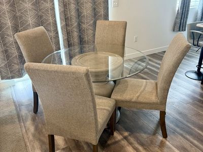 Glass Top Dining Table with Pedestal Base & 4 Upholstered Chairs