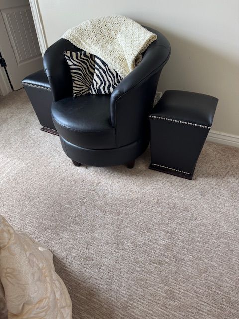 modern barrel chair with matching ottoman, upholstered in black faux leather (or bonded leather)