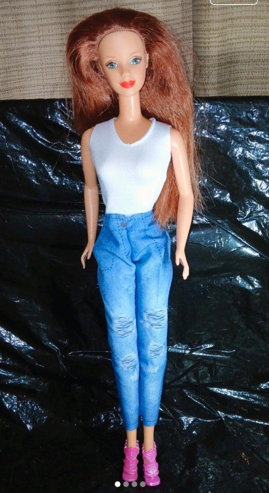 A 2007 Birthstone Beauties Steffie face redhead barbie doll head on a vintage barbie body.
