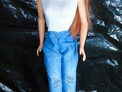 A 2007 Birthstone Beauties Steffie face redhead barbie doll head on a vintage barbie body.