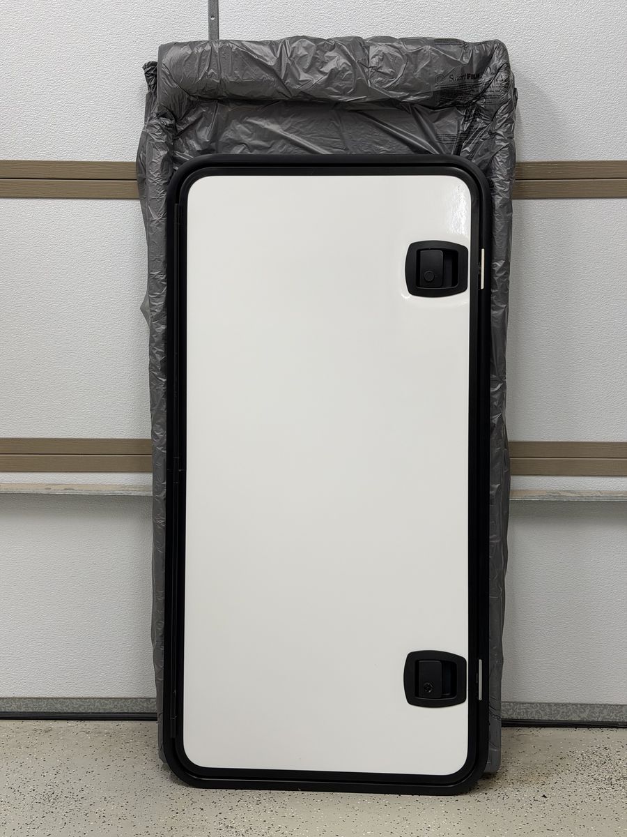 RV double latch storage bay door. NEW in original box. 50 x 25 inch. Includes mounting frame.