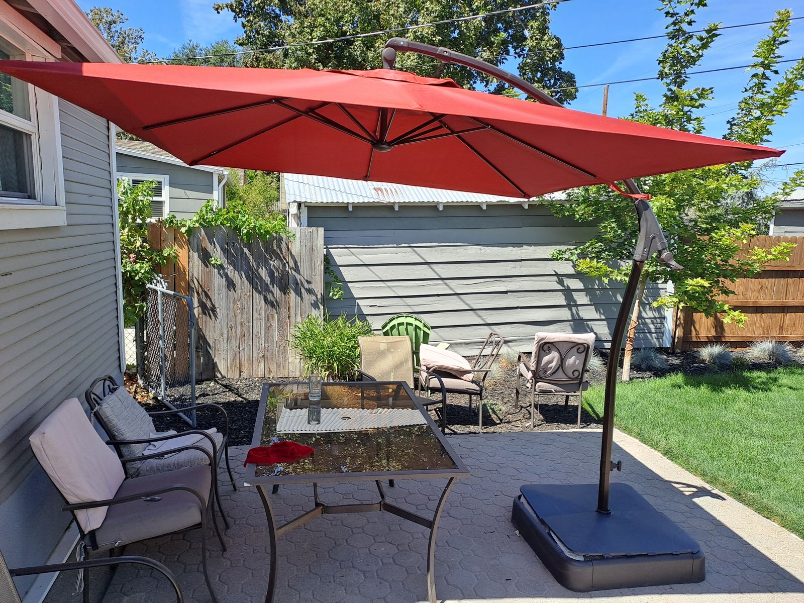 Cantilever-style patio shade umbrella 8'x8' with weighted base + sandbags.