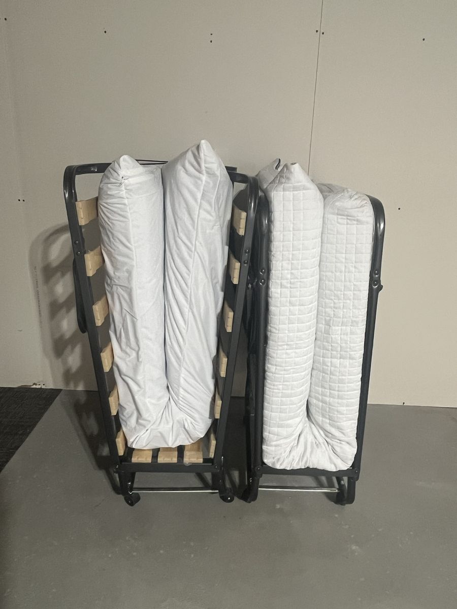 Two foldable guest beds with mattresses and covers