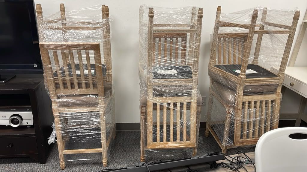 Set of rustic counter-height wooden chairs with a sturdy wood frame and high backrest.