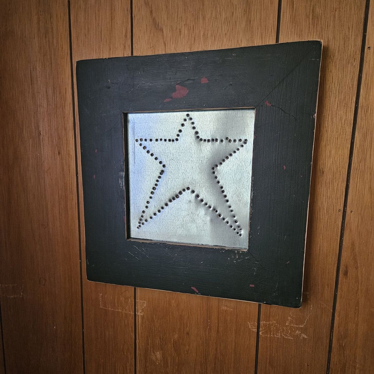 Black wood frame with a hammered metal star