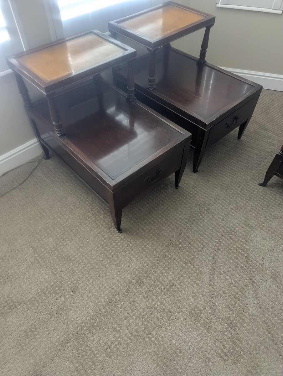 Vintage tables featuring mahogany dark wood frames and brown leather tops with gold inlay.
